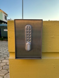 a keypad mounted on the side of a yellow wall