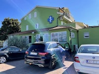 two cars parked in front of a green building