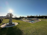 a view of a lawn with a fountain and a pool