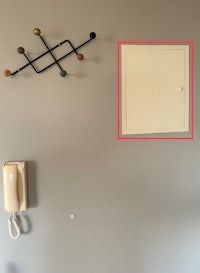 a wall mounted telephone with a white box on it