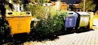 a group of trash cans on a sidewalk