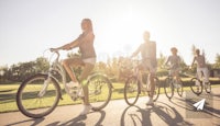 a group of people riding bicycles in a park stock photo