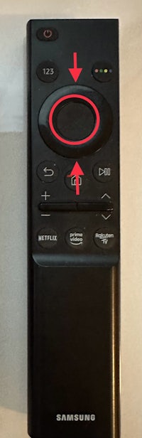 a samsung tv remote with a red arrow pointing to it