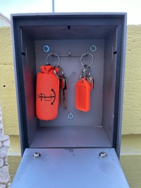 an orange key holder is attached to a metal box