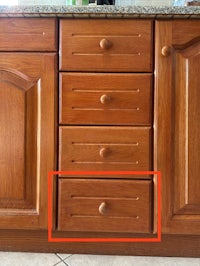 a picture of a kitchen cabinet with a red circle on it