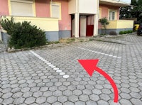 a red arrow pointing to a parking space in front of a building