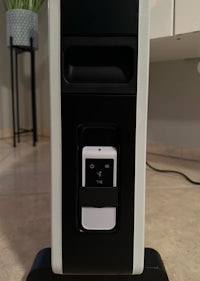 a black and white air purifier with a cell phone attached to it