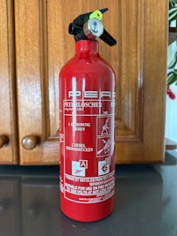 a red fire extinguisher sitting on a counter